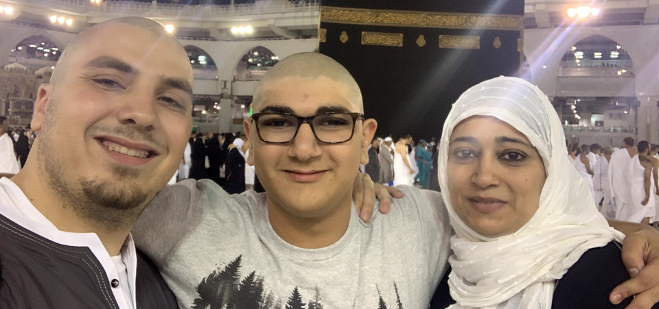Two men and a woman smiling infront of the kabah
