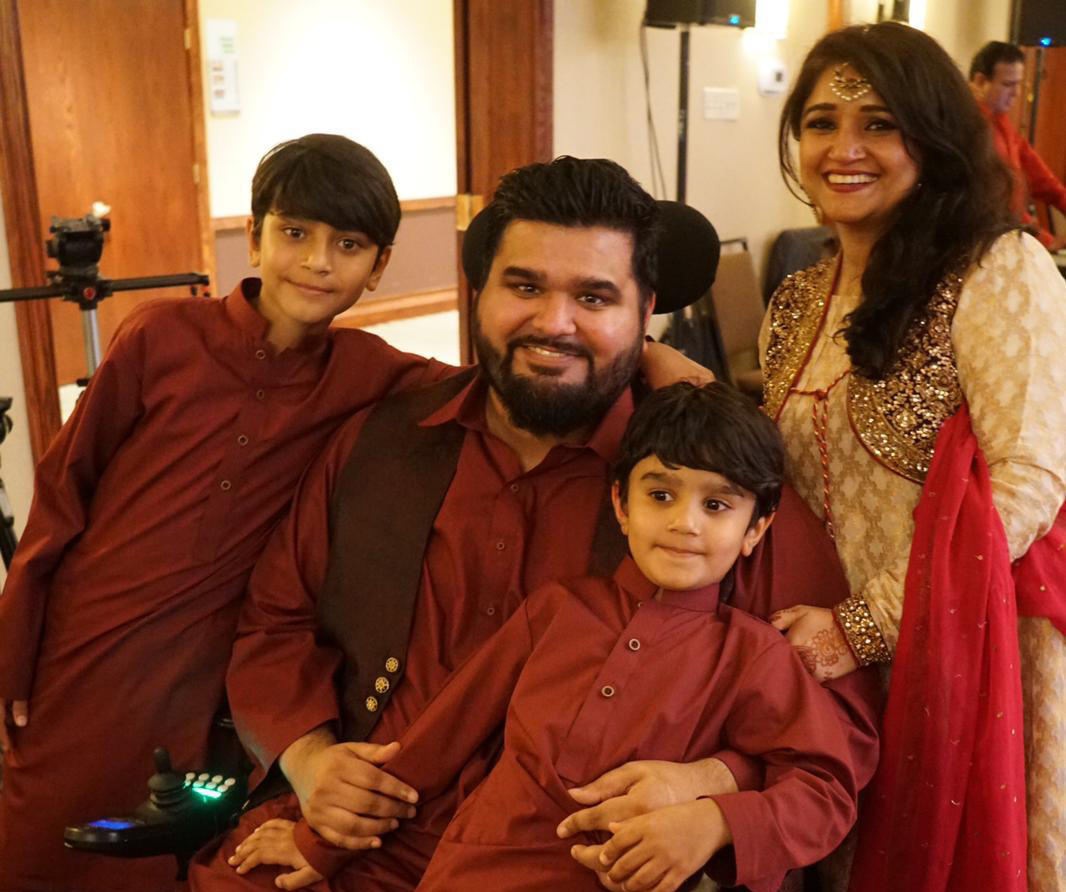 A photo of Omer Zaman (Board member) smiling with his wife and two children