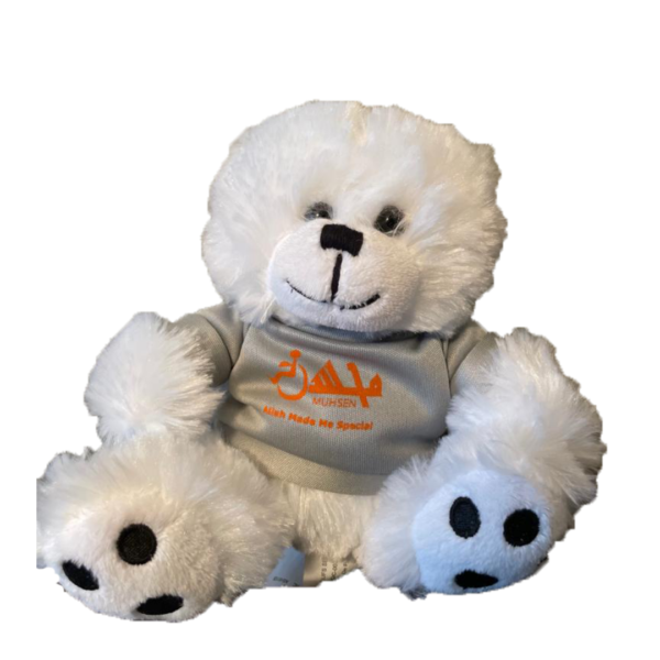 White teddy bear wearing a gray shirt and an orange muhsen logo. Text says Allah made me special
